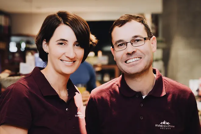 Foto der Apotheken Inhaber. Die Frau und der Mann lachen beide in die Kamera.